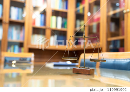 Old Brass Law Scale vintage style is laid on wood glass table in Lawyer office meeting room. 119991902