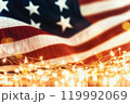 Sparkles with lights in soft focus and American flag on the background. July forth celebration. The Independence day backdrop. Abstract minimalistic wallpaper with space for text.  119992069