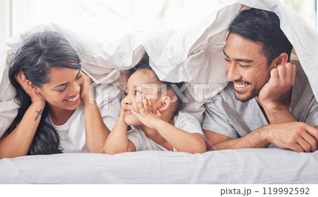 Child, parents and family smile in bed with love relationship, support and happy bonding under blanket in home. Mother, father and young girl on mattress for morning with wake up together and relax Child, parents and family smile in bed with love relationship, support and happy bonding under blanket in home. Mother, father and young girl on mattress for morning with wake up together and relax 119992592