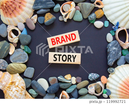 Brand story symbol. Concept words Brand story on beautiful wooden blocks. Beautiful black background. Beautiful sea stones shell. Business brand story concept. Copy space. Brand story symbol. Concept words Brand story on beautiful wooden blocks. Beautiful black background. Beautiful sea stones shell. Business brand story concept. Copy space. 119992721
