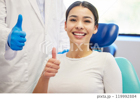 Dentist, client and smile with portrait for thumbs up for success of teeth whitening, oral and dental care. Doctor, assistant and woman with hand gesture for well done or good job, yes and thank you. Dentist, client and smile with portrait for thumbs up for success of teeth whitening, oral and dental care. Doctor, assistant and woman with hand gesture for well done or good job, yes and thank you. 119992884