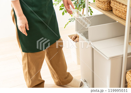 資源ゴミを分別して捨てるミドル〜シニア女性の手元 119995031