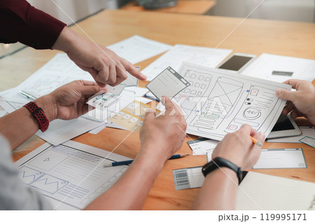 UX or UI designers designing on digital tablet and smartphone application layout prototype project. UX or UI designers designing on digital tablet and smartphone application layout prototype project. 119995171