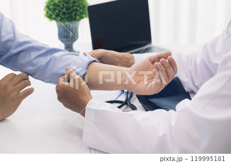 The doctor rolls up the patient's sleeve to measure blood pressure or give an injection. 119995181
