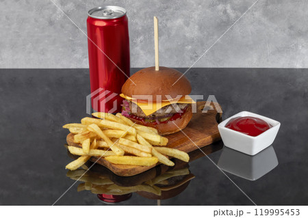 Burger on a wooden board with a patty, tomato, cheese, cucumber and lettuce. Burger on a wooden board with a patty, tomato, cheese, cucumber and lettuce. 119995453
