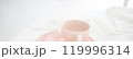 Tender pink mug on light background. Ceramic coffee cup for montage or design. 119996314