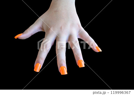 Girl's hands with orange false nails on a black background. female manicure 119996367