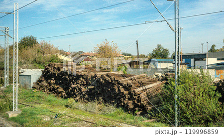 Wooden beams of different sizes. Lumber. Concept - sale of wood for construction. Piles of wooden beams lie on the ground. Concept - Buying wooden slings for building a house. Open-air lumber. High Wooden beams of different sizes. Lumber. Concept - sale of wood for construction. Piles of wooden beams lie on the ground. Concept - Buying wooden slings for building a house. Open-air lumber. High 119996859