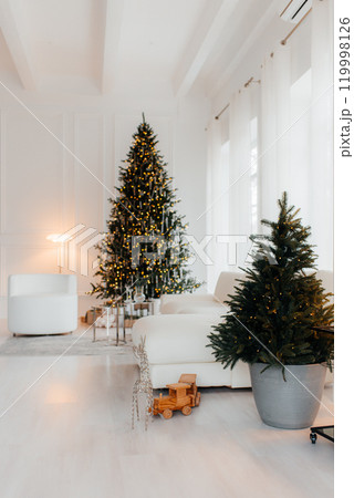 Room with Christmas decorations, white sofa adorned with lights, cozy blanket, Christmas tree decorated with ornaments, gold gift boxes, staircase, elegant and festive Room with Christmas decorations, white sofa adorned with lights, cozy blanket, Christmas tree decorated with ornaments, gold gift boxes, staircase, elegant and festive 119998126