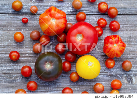 Variety of colourful organic tomatoes on the gray wooden table. 119998394