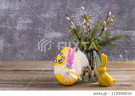 Wooden table with Easter bunny, egg and bunch of willow. 119998656