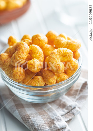 Puffed crispy Peanut flips in bowl on white table. 119999682