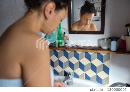 Woman reflecting in bathroom mirror after morning shower 120000095