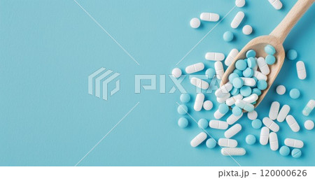 heap of medical pills and drugs in capsules in spoon on blue background, healthcare and medicine pharmacy background 120000626