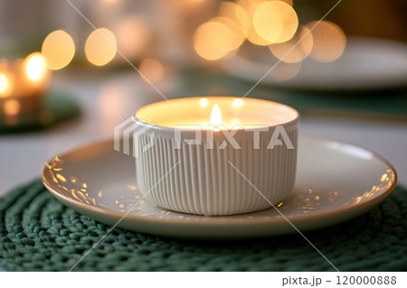 A cozy candle in a white dish on a dinner table 120000888