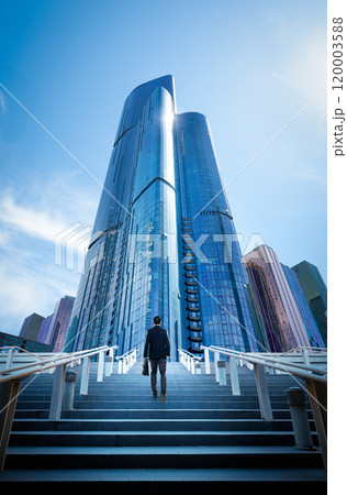 Businessman walking up stairs to modern office building 120003588