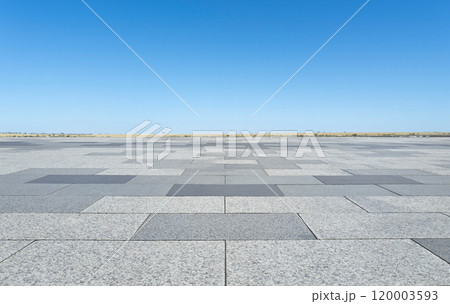 Empty square made of stone tiles under blue sky 120003593