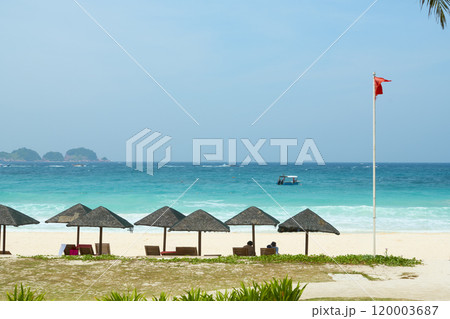 Tourists relaxing under thatched umbrellas on redang island beach 120003687