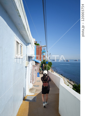Young woman walking on a path in huinnyeoul culture village, busan, south korea 120003754