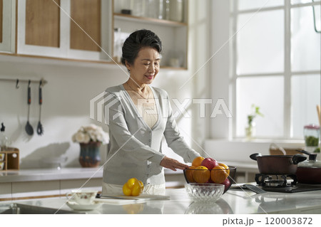 asian elderly woman standing in modern kitchen at home 120003872
