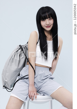 Korean Woman in Her 20s Poses Sitting on Chair in Block Core fashion Korean Woman in Her 20s Poses Sitting on Chair in Block Core fashion 120005042