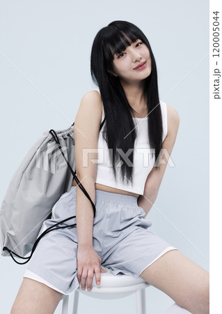 Korean Woman in Her 20s Poses Sitting on Chair in Block Core fashion Korean Woman in Her 20s Poses Sitting on Chair in Block Core fashion 120005044