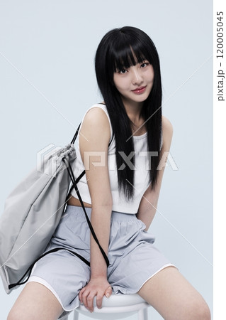 Korean Woman in Her 20s Poses Sitting on Chair in Block Core fashion Korean Woman in Her 20s Poses Sitting on Chair in Block Core fashion 120005045