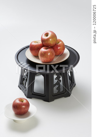 A pile of apples placed on a plate above and below the refreshment table. 120006725