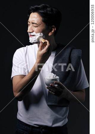 Middleaged man applying foam to his face with a shaving brush 120006938