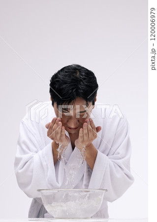 Middleaged man washing his face with water Middleaged man washing his face with water 120006979