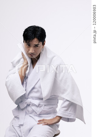Middleaged man wiping his face with a white towel Middleaged man wiping his face with a white towel 120006983