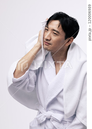 Middleaged man wiping his face with a white towel 120006989