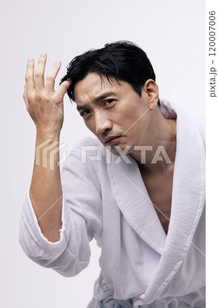 Middleaged man touching his bangs with his hand Middleaged man touching his bangs with his hand 120007006