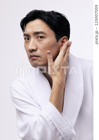 Middleaged man touching his chin with his hand 120007009