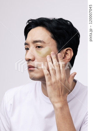 A middleaged man putting an eye patch around his eyes 120007045