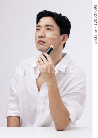 A middleaged man staring into the distance with foundation on his face 120007098