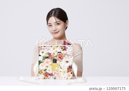 A woman holding a letter to be delivered along with beautifully packaged cosmetics 120007175