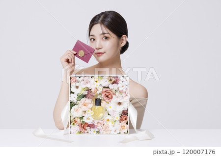 A woman holding a letter to be delivered along with beautifully packaged cosmetics A woman holding a letter to be delivered along with beautifully packaged cosmetics 120007176