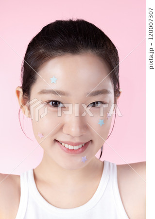 A teenage woman with a sticker on her face and a cute expression on her face 120007307