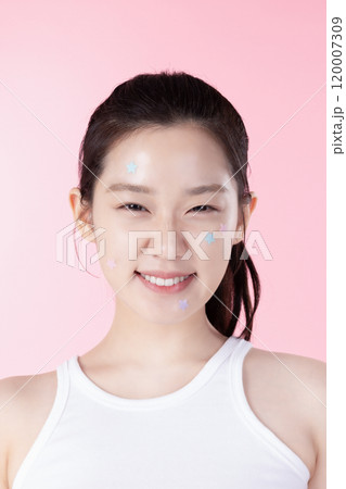 A teenage woman with a sticker on her face and a cute expression on her face A teenage woman with a sticker on her face and a cute expression on her face 120007309