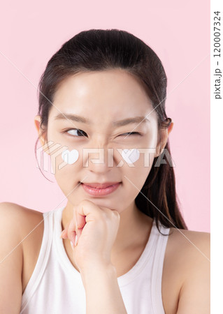 A teenage woman with a sticker on her face and a cute expression on her face 120007324