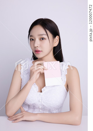 A woman in her 20s posing with a personal color drape swatch. 120007472