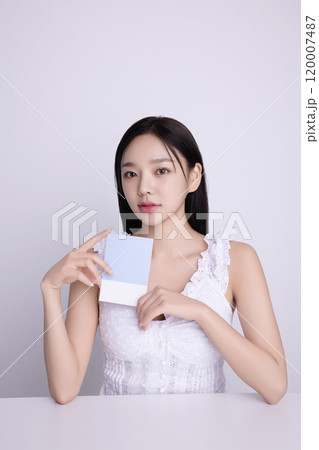 A woman in her 20s posing with a personal color drape swatch. 120007487