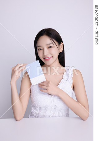 A woman in her 20s posing with a personal color drape swatch. 120007489