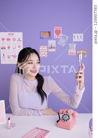 A woman in her 20s holding a kitschy item and holding various poses 120007565