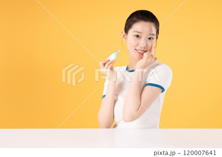 Teenage woman using skincare products to remove skin problems on her face Teenage woman using skincare products to remove skin problems on her face 120007641