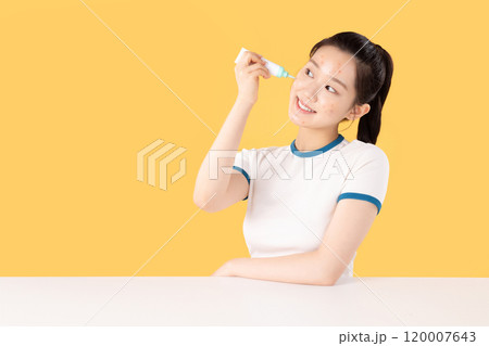 Teenage woman using skincare products to remove skin problems on her face 120007643
