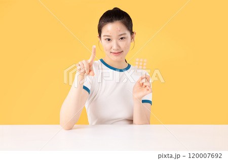 Teenage woman using skincare products to remove skin problems on her face 120007692