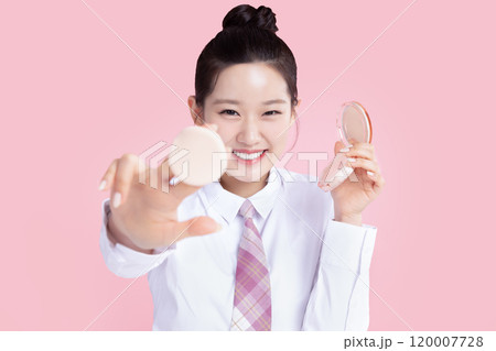 A teenage woman wearing a school uniform and holding cosmetics in a cute pose 120007728