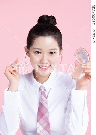 A teenage woman wearing a school uniform and holding cosmetics in a cute pose 120007729